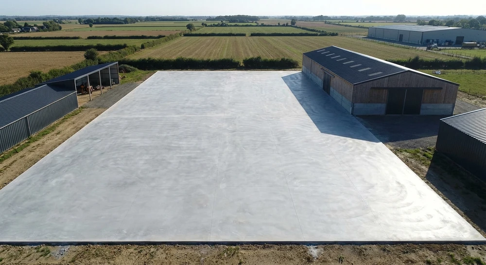 Ouvriers en chantier extérieur effectuant le lissage d'une dalle de béton frais